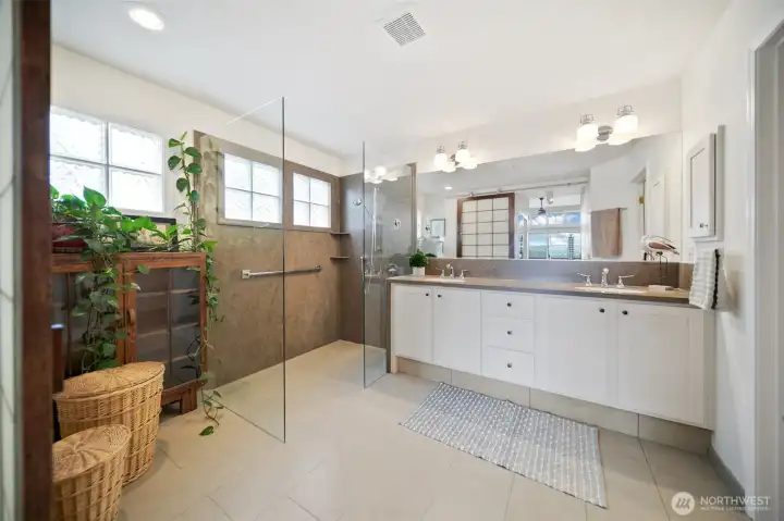 Wow! The breathtaking primary bath features no-step walk-in shower, gorgeous tile floors and a stylish shoji sliding door for added privacy.(view in mirrow)