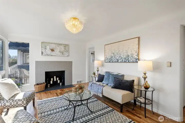 The living room welcomes you with period coved ceilings, refinished oak hardwoods, and a classic wood-burning fireplace.