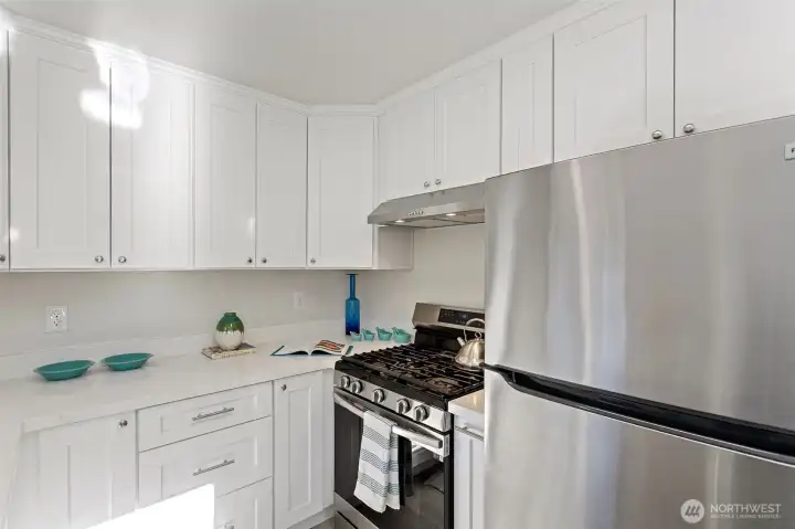 Stainless appliances, updated lighting, and generous counter space make the kitchen both practical and inviting.