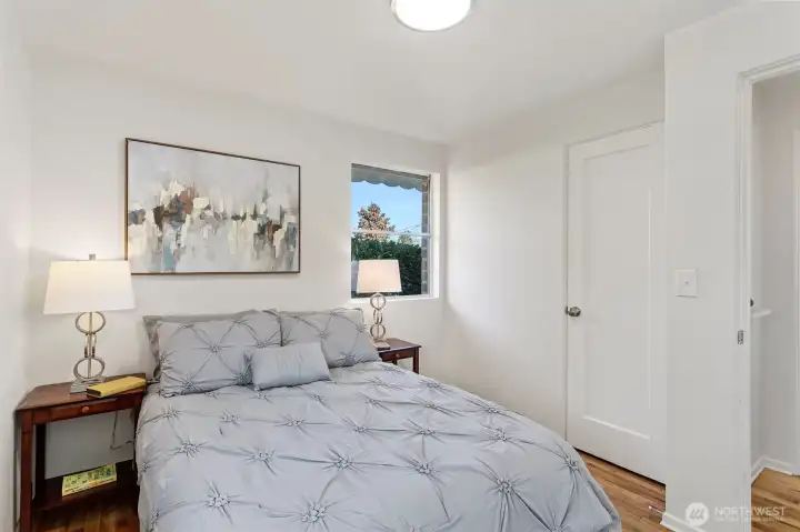 A quiet back bedroom with a north-facing window, hardwood floors, and a simple, functional footprint.