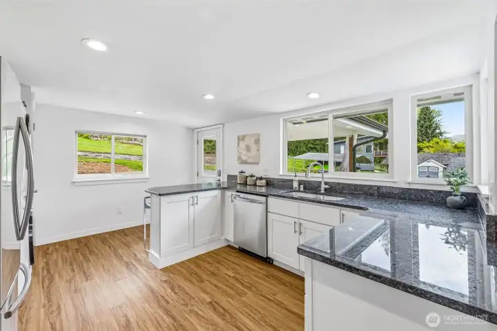 An open concept kitchen with granite counters.