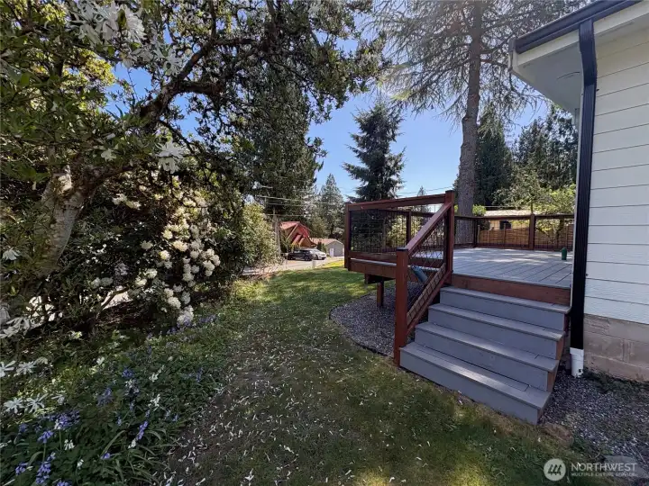 The deck has stairs leading down to the side yard.