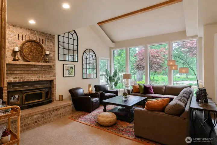 Living room with gorgeous brick fireplace, huge windows and vaulted ceilings. Look at the view to the outdoors Living room with gorgeous brick fireplace, huge windows and vaulted ceilings. Look at the view to the outdoors