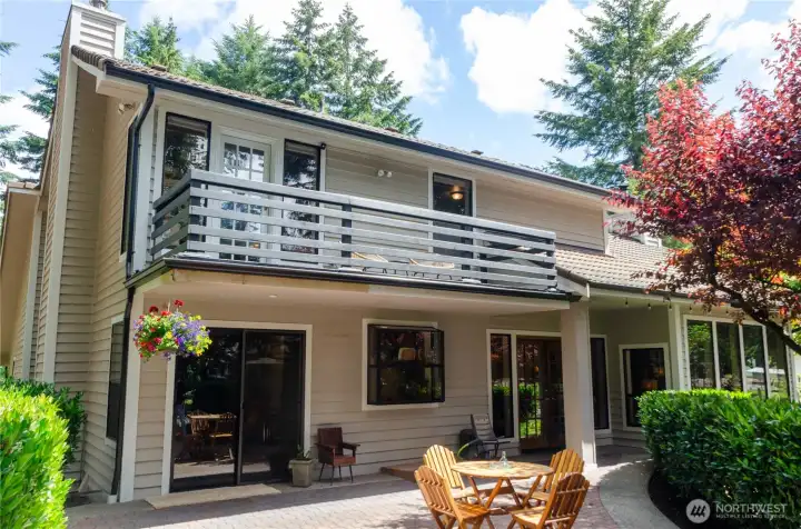 Back of the home showing the sitting deck of the Primary and the patio outside the kitchen and dining room Back of the home showing the sitting deck of the Primary and the patio outside the kitchen and dining room