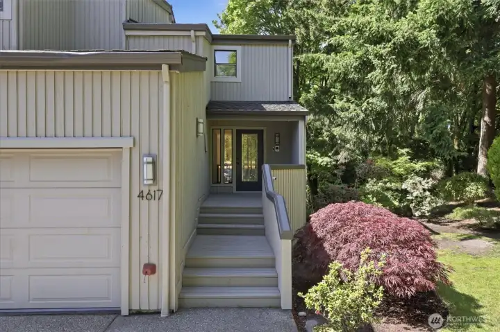 Inviting covered entry with updated front door, lush landscaping, and a peaceful wooded backdrop creating exceptional privacy. Inviting covered entry with updated front door, lush landscaping, and a peaceful wooded backdrop creating exceptional privacy.