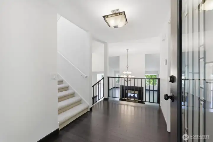 Bright and spacious foyer with soaring ceilings, rich hardwood flooring, and an open sightline into the home's main living spaces. Bright and spacious foyer with soaring ceilings, rich hardwood flooring, and an open sightline into the home's main living spaces.