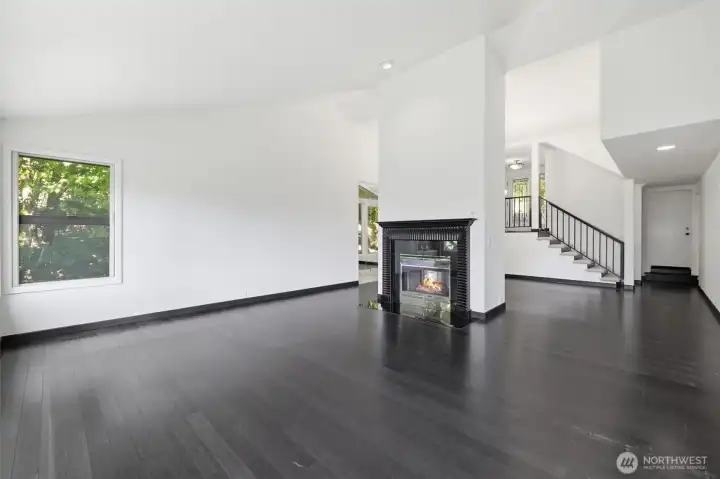 Expansive great room anchored by a striking dual-sided fireplace, featuring soaring ceilings, rich hardwood flooring, and seamless flow throughout the main living spaces. Expansive great room anchored by a striking dual-sided fireplace, featuring soaring ceilings, rich hardwood flooring, and seamless flow throughout the main living spaces.
