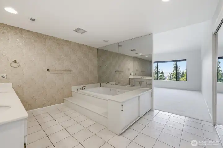 Expansive spa-inspired primary bath with soaking tub, separate shower, dual vanities, and a tranquil retreat-like atmosphere. Expansive spa-inspired primary bath with soaking tub, separate shower, dual vanities, and a tranquil retreat-like atmosphere.