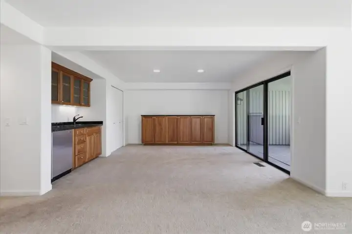Entertain with ease in the lower-level gathering space featuring a wet bar, built-in cabinetry, and direct access to a covered outdoor patio. Entertain with ease in the lower-level gathering space featuring a wet bar, built-in cabinetry, and direct access to a covered outdoor patio.