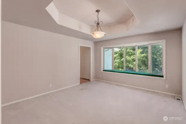 The Bay Window and Coffered Ceiling add so much Character to this Office / Dining Room or  Large Den next to a  Hallway that passes the Dry Bar and into the Kitchen