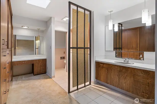 A different perspective of the primary bathroom showcases built-in closets and a thoughtfully designed privacy screen.