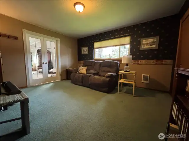 Another view of the den and the primary bedroom through the French doors.