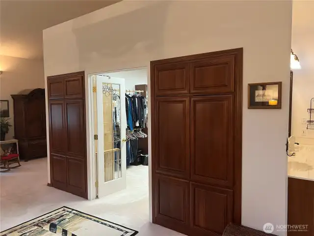 A walk-in closet that is as big as a bedroom. Built-in cabinets on either side of the French door closet.