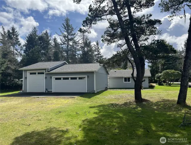 Three car garage/shop large enough for a mid-sized RV. RV Parking on the side of the garage with electric and water hookups