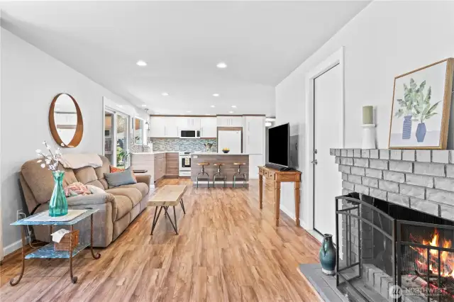 Warm and welcoming living space complete with a wood-burning fireplace, stylish brick surround, and open flow to the gourmet kitchen—ideal for entertaining year-round.