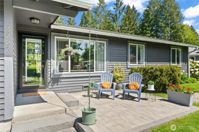 Step up to the inviting front paver patio complete with custom seating, charming planters, and a modern storm door entry. Enjoy morning coffee or evening chats in this peaceful space designed for comfort and curbside relaxation.