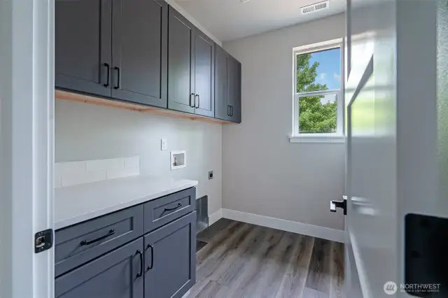 Well equipped laundry with cabinetry and space to work