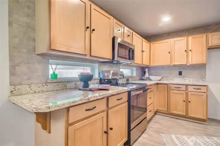 The kitchen features obscured windows that fill the space with soft natural light while maintaining privacy.
