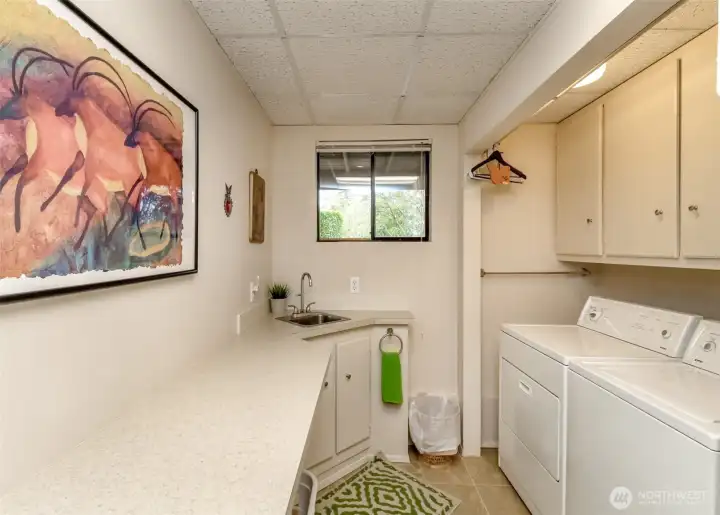 Large Laundry Room with ample cabinetry and utility sink.