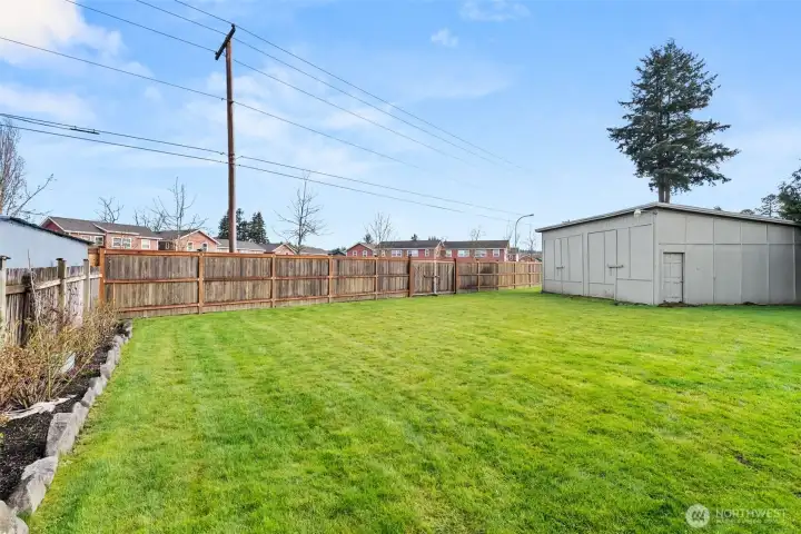 Spacious level backyard with sprinkler system