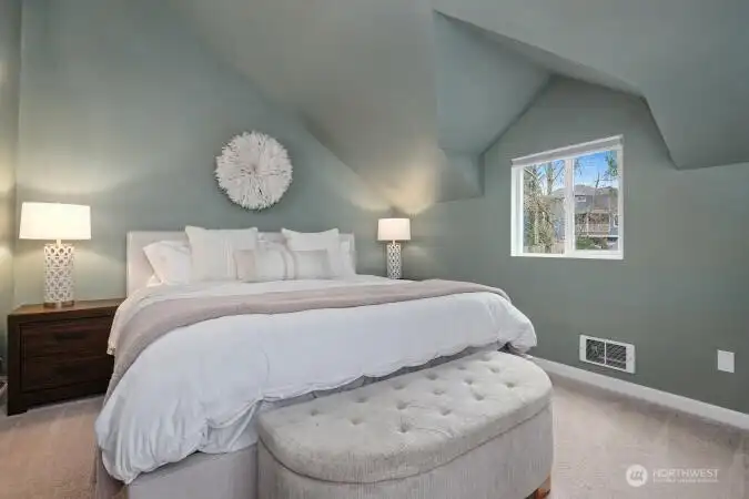 Spacious primary bedroom with vaulted ceilings.
