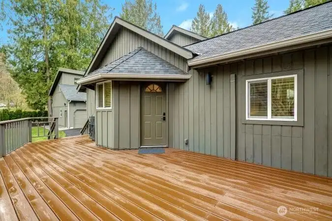 Entertainment size deck on side of home adjacent to new patio & fire pit and beautiful yard next to creek