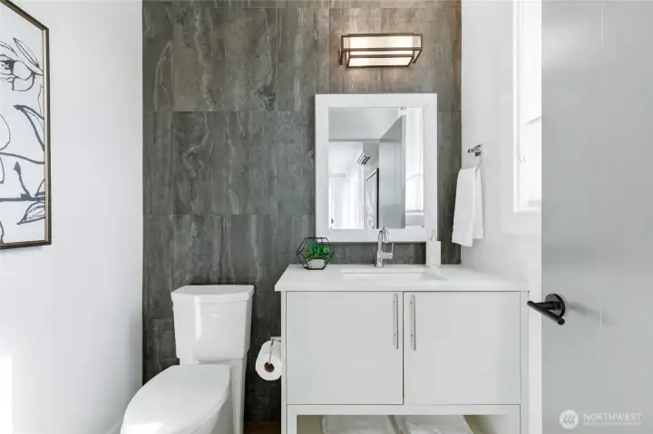 Powder room for guests with impeccable modern design and tile wrapped wall