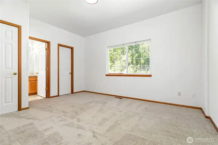 Primary bedroom with walk-in closet and attached full bath face backyard