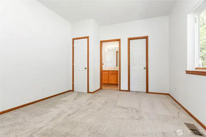 Primary bedroom with walk-in closet and attached full bath face backyard