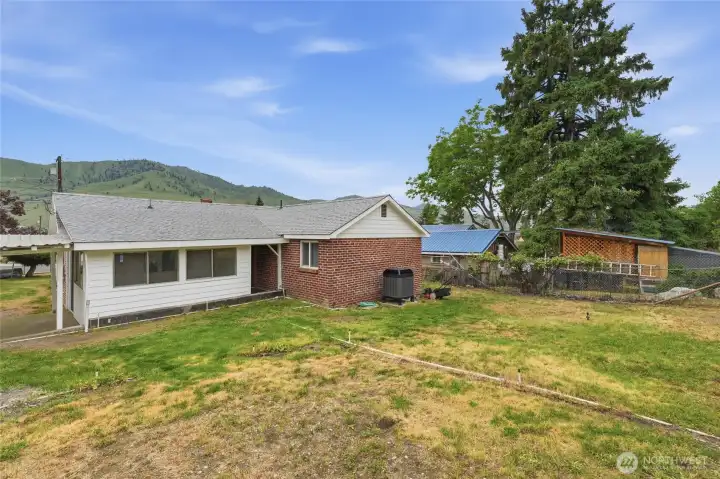 Large backyard with sprinkler system and grapes