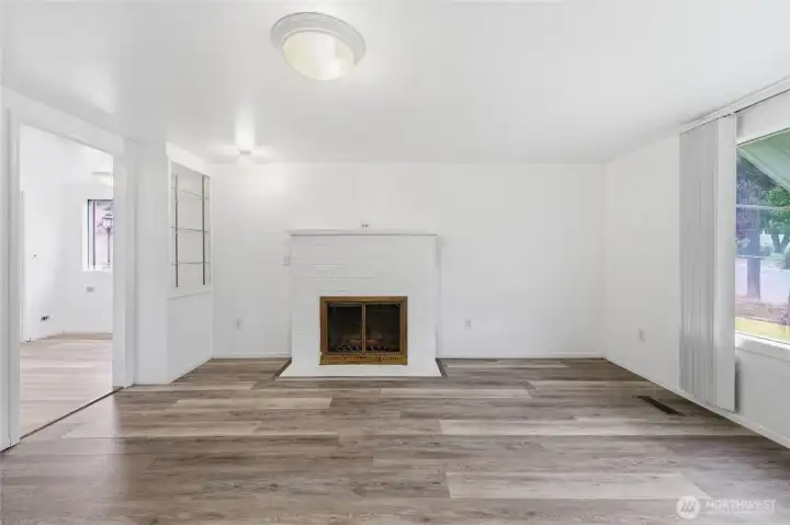 Living room with new floors and beautiful wood fireplace