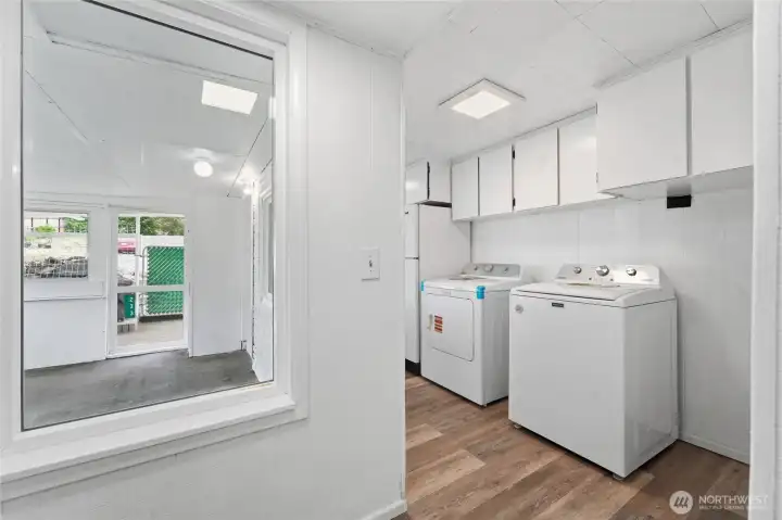 Washer, new dryer, refrigerator with view of closed in patio