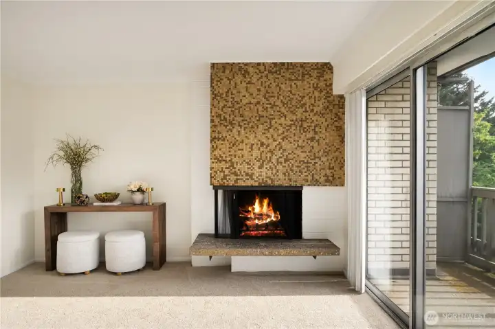 The wood burning fireplace is framed by retro mosaic tiles and a floating stone hearth. The wood burning fireplace is framed by retro mosaic tiles and a floating stone hearth.