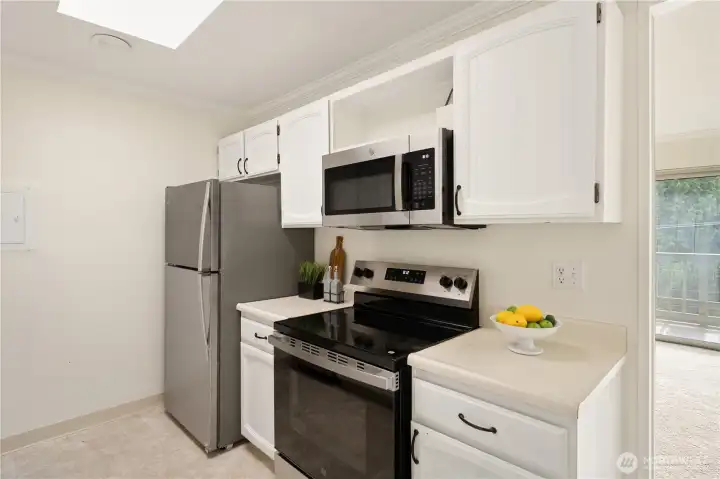 The kitchen features can lights and a skylight providing natural light. The kitchen features can lights and a skylight providing natural light.
