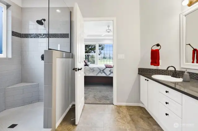 Updated primary bathroom suite features a huge walk-in-shower, double sink vanity, and spacious walk-in-closet.