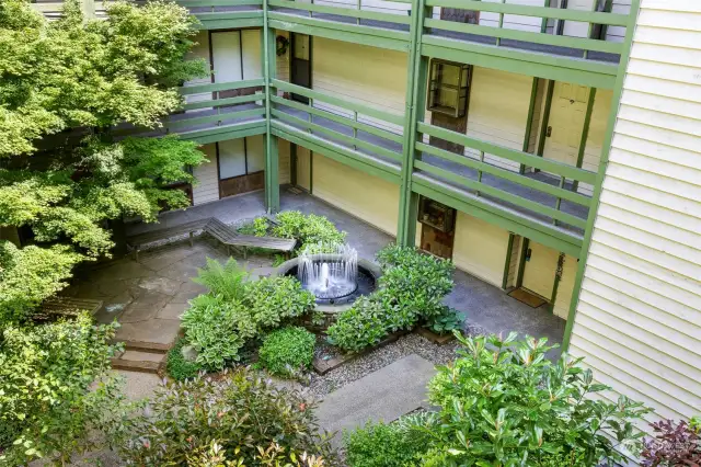 Courtyard features lush plantings and water feature.