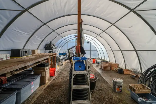 Interior of Greenhouse includes Commercial Exhaust Fan, Worktable, Shelving Units, Raised Beds, etc.