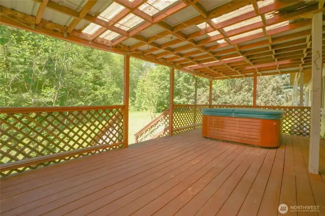 Covered back porch with hot tub.