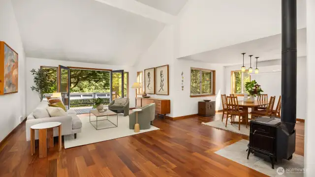 The living room exudes warmth and character with rich teak floors that glow in natural light. Whether you're curled up by the fireplace or entertaining guests, the space feels both elegant and welcoming.