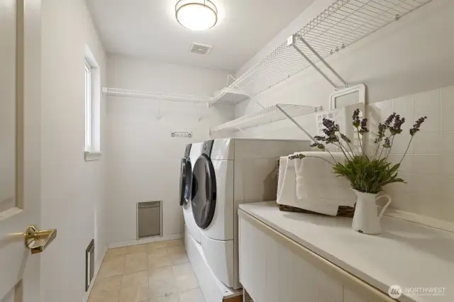 Main floor laundry room with lots of counter and storage space.