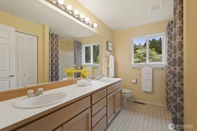 Upstairs hall bath has dual vanities, soaking tub, and shower.