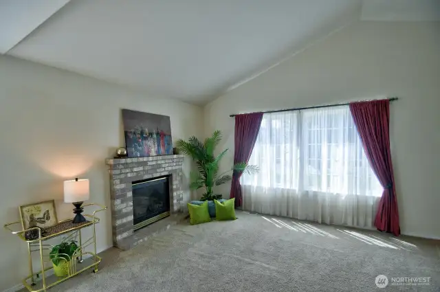 Vaulted ceilings, natural gas fireplace and grand picture window are features of the living room
