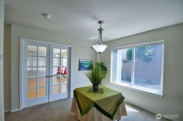 Dining area overlooks the backyard patio space. French doors creates some privacy from kitchen/family room