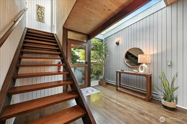 Sunlit stairwell leads to the coastal-inspired primary bedroom. where sweeping ocean views and soft sea breezes await.