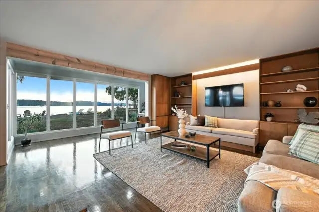 Puget Sound views from this well-loved living room with expansive windows, rich hardwoods, and seamless indoor-outdoor flow.
