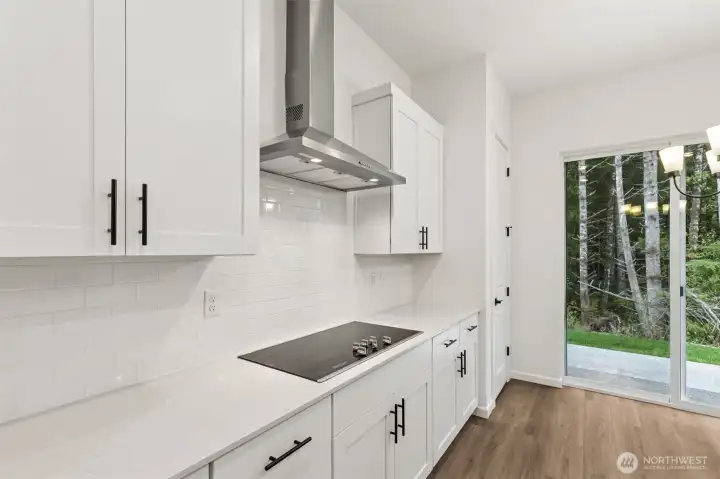 ***Actual Home *** Kitchen and dining area - GE Profile appliances and hood vent with tiled back splash