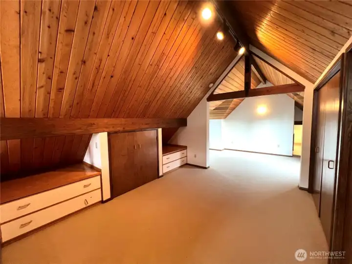 A feeling of a cabin in the woods continues to the second floor where the primary bedroom has separate spaces.