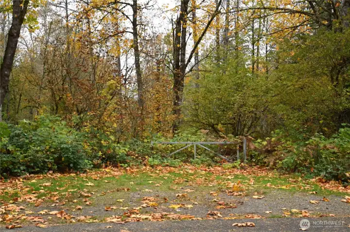 1.31 Acre riverfront property ~ beautifully treed for privacy.  Walking trail to right of gate.