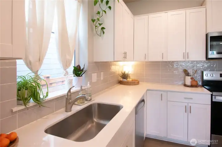 Large kitchen sink with quarts countertops.