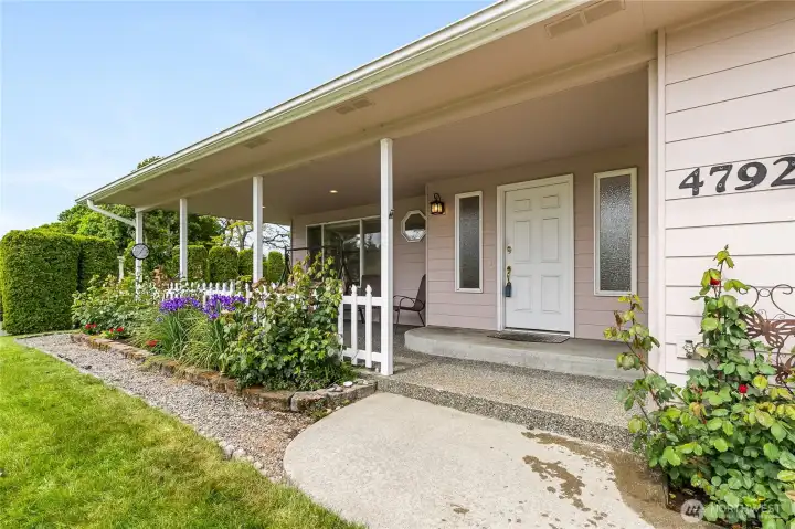 Roses and other flowers at the front. Beautiful covered patio and entrance into the home.